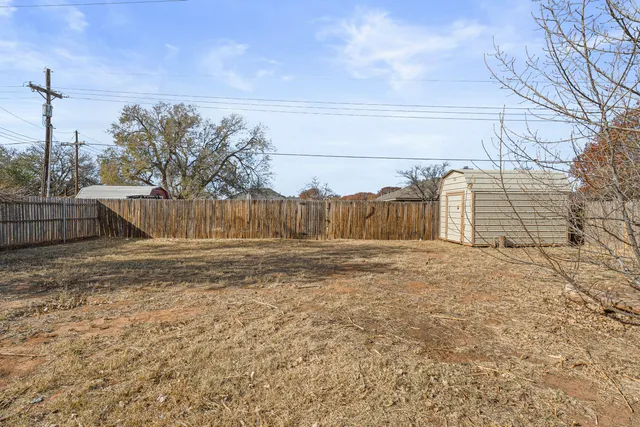 a view of a yard with wooden fence
