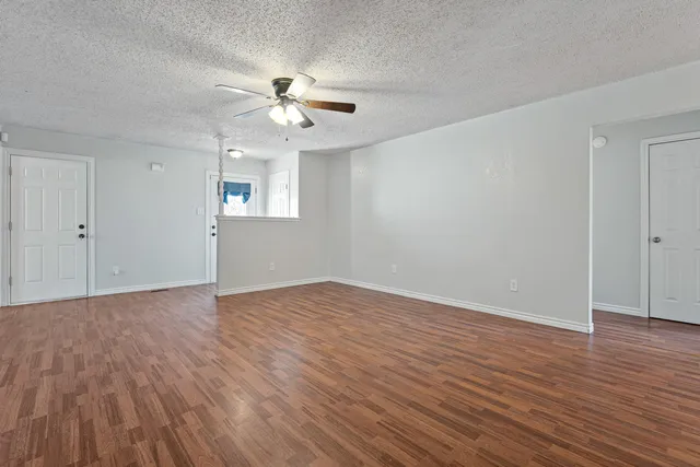 a view of an empty room with wooden floor