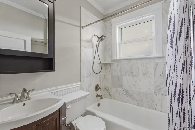 a bathroom with a granite countertop sink a toilet and shower