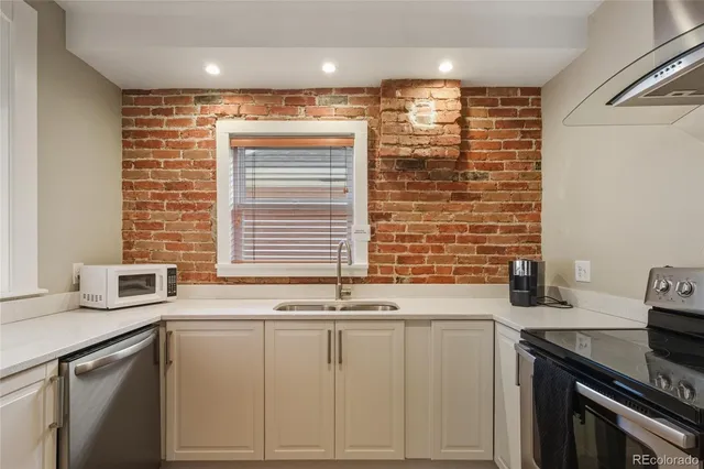 a kitchen with stainless steel appliances cabinets and a large window