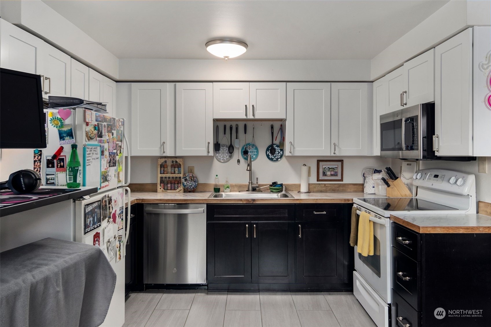 220 Southwest Clark Street, Unit B302 Issaquah, WA 98027 - Photo 9 of 20 a kitchen with kitchen island granite countertop a sink dishwasher stove and cabinets with wooden floor