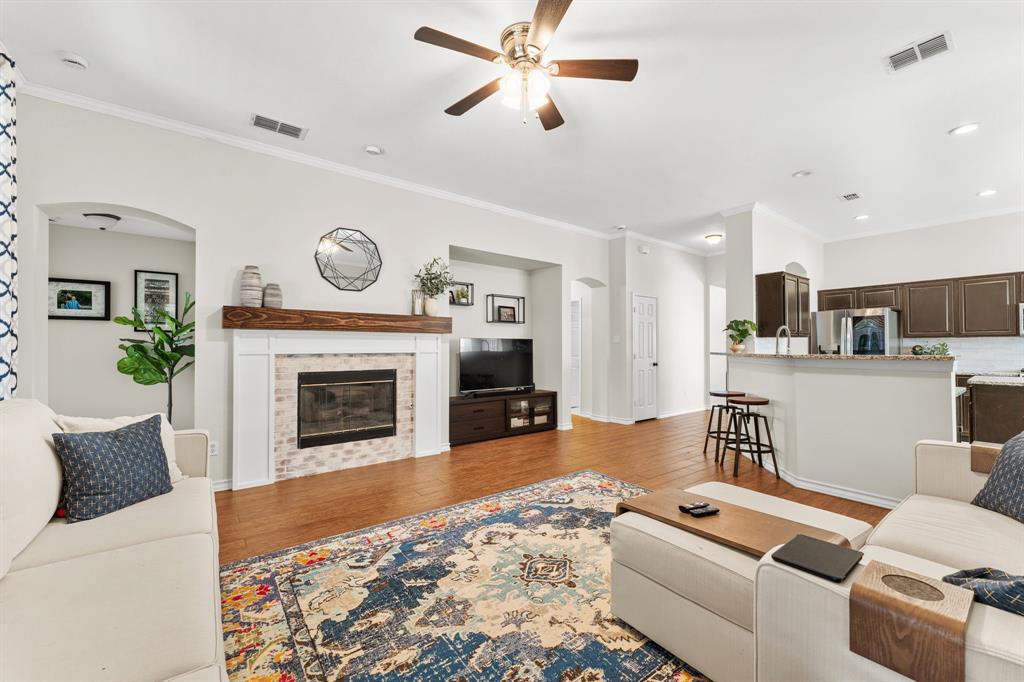 7321 Summit View Lane Sachse, TX 75048 - Photo 12 of 28 a living room with furniture a fireplace and kitchen view