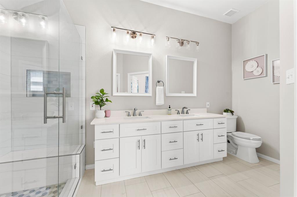 7321 Summit View Lane Sachse, TX 75048 - Photo 19 of 28 a bathroom with a double vanity sink a toilet and a mirror