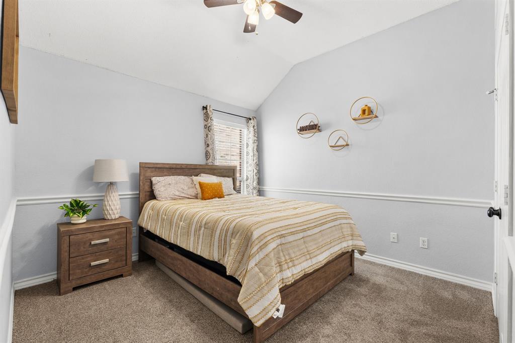 7321 Summit View Lane Sachse, TX 75048 - Photo 23 of 28 a bedroom with a bed and a chandelier fan