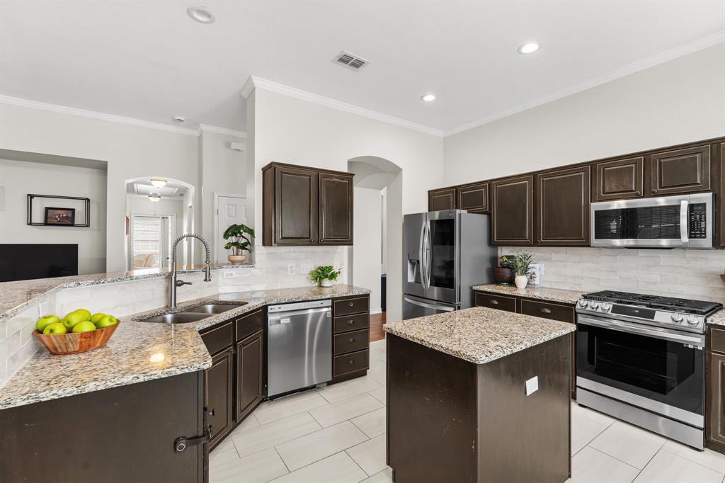 7321 Summit View Lane Sachse, TX 75048 - Photo 8 of 28 a kitchen with stainless steel appliances granite countertop a sink stove and refrigerator
