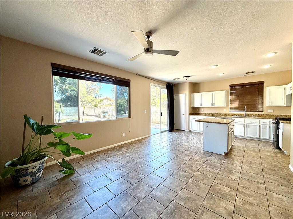 3936 Gold Point Street Las Vegas, NV 89129 - Photo 2 of 23 A combined kitchen and living area offers seamless indoor-outdoor living with a bright patio view.