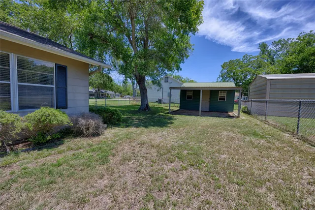 a view of a house with backyard and a tree