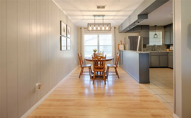 a dining room with furniture a chandelier and wooden floor