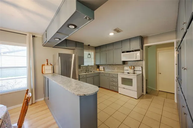 a large kitchen with a stove a refrigerator and a sink