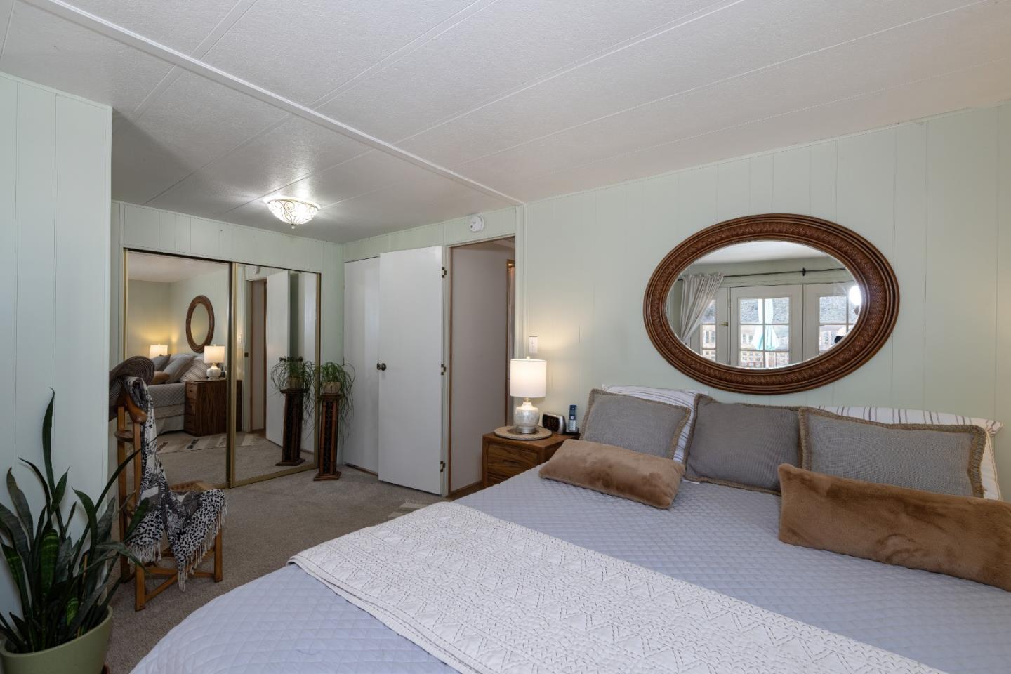 270 Hames Road, Unit 16 Corralitos, CA 95076 - Photo 16 of 20 a bedroom with a bed a mirror and a potted plant