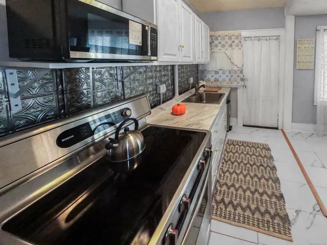 a kitchen with stainless steel appliances a sink stove refrigerator and cabinets