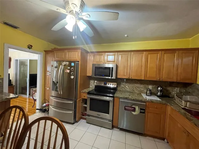 a kitchen with stainless steel appliances granite countertop a stove refrigerator and microwave