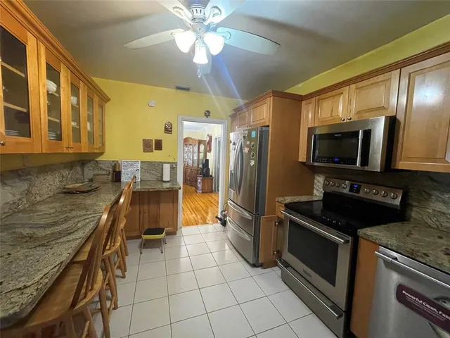 a kitchen with stainless steel appliances granite countertop a stove a sink and a refrigerator