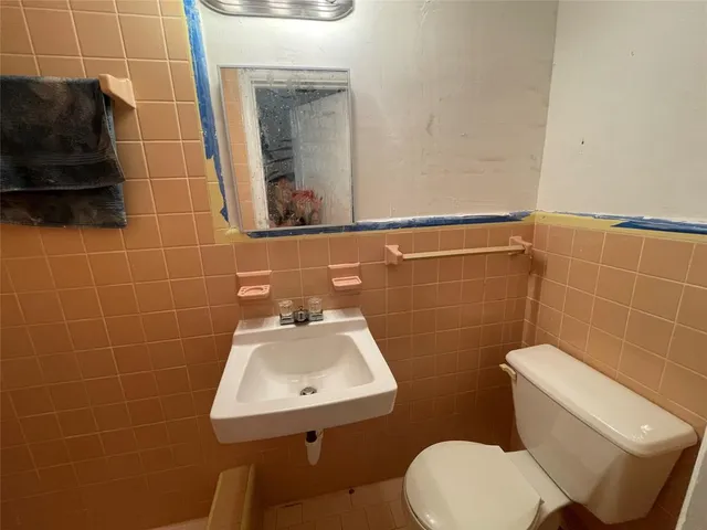 a bathroom with a toilet sink and mirror