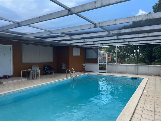 a view of a swimming pool with chairs in patio