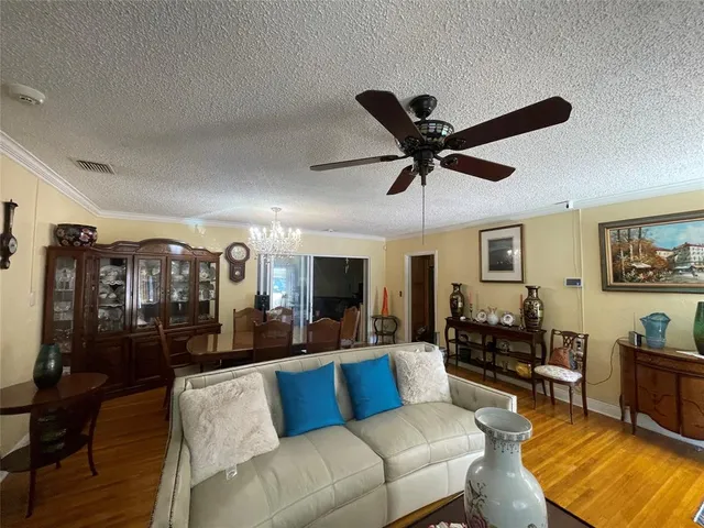 a living room with furniture kitchen view and a wooden floor
