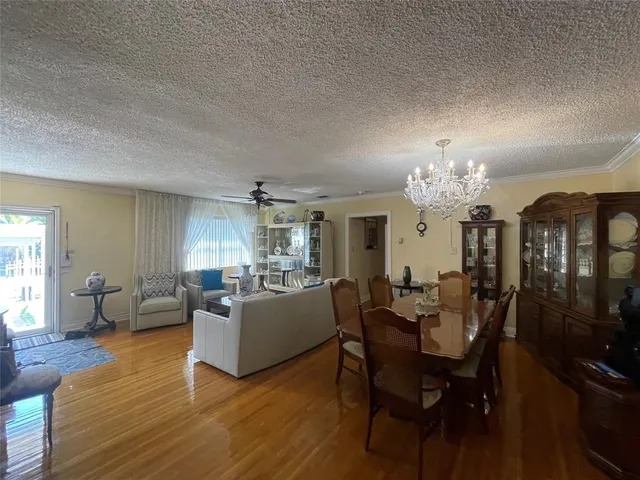 a view of a dining room with furniture a chandelier and wooden floor