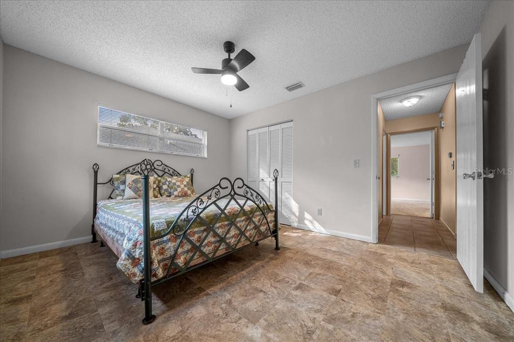 9152 Southwest 89th Terrace, Unit D Ocala, FL 34481 - Photo 20 of 39 a bedroom with a bed and a chandelier