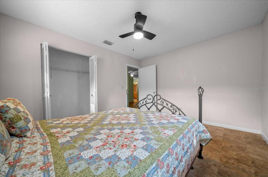 9152 Southwest 89th Terrace, Unit D Ocala, FL 34481 - Photo 21 of 39 a bedroom with a large bed and a chandelier