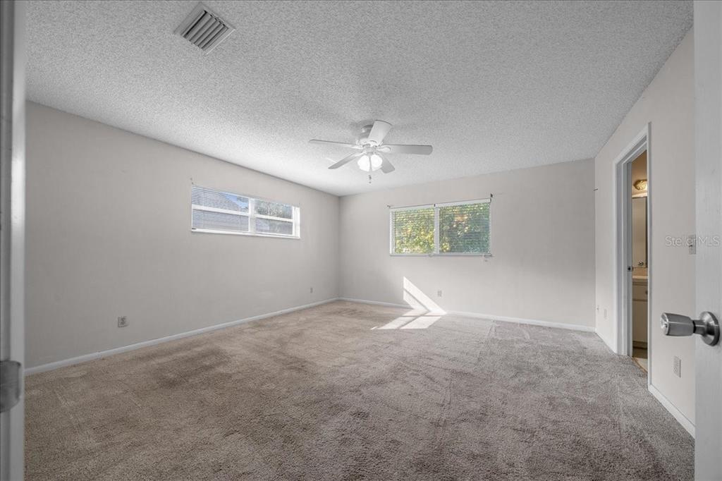9152 Southwest 89th Terrace, Unit D Ocala, FL 34481 - Photo 29 of 39 an empty room with windows and fan