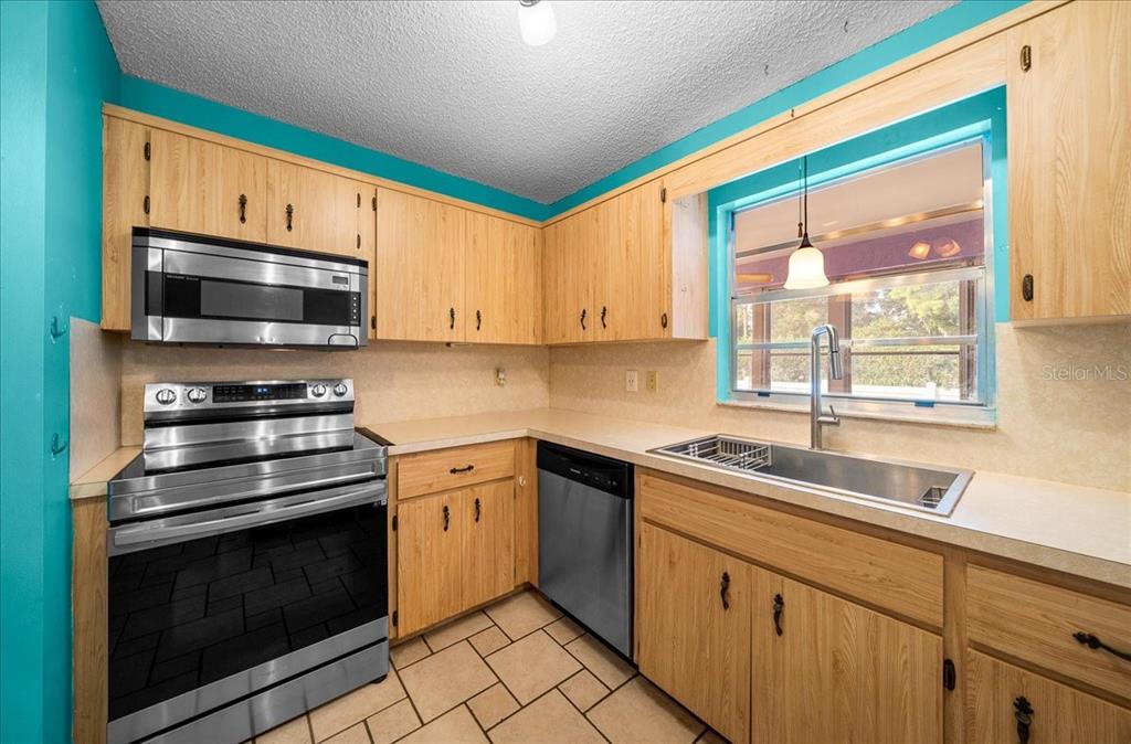 9152 Southwest 89th Terrace, Unit D Ocala, FL 34481 - Photo 36 of 39 a kitchen with stainless steel appliances a stove sink and microwave