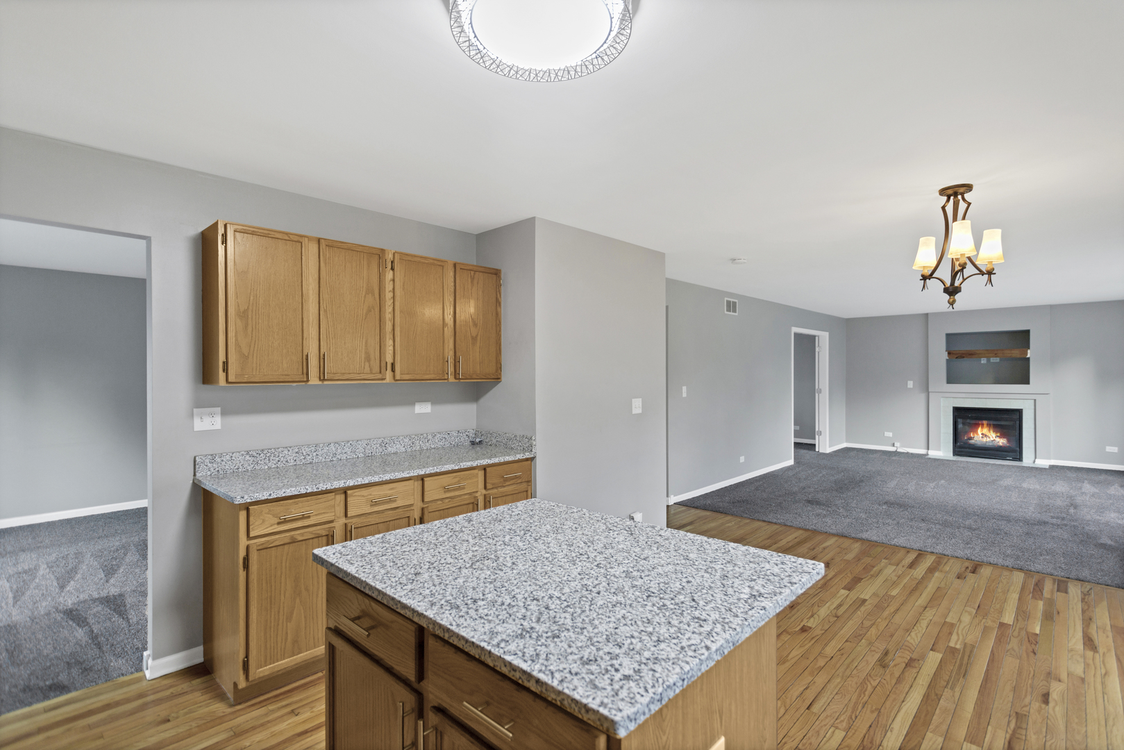85 Old Post Road Oswego, IL 60543 - Photo 16 of 38 a kitchen with a sink a granite counter top and a fireplace