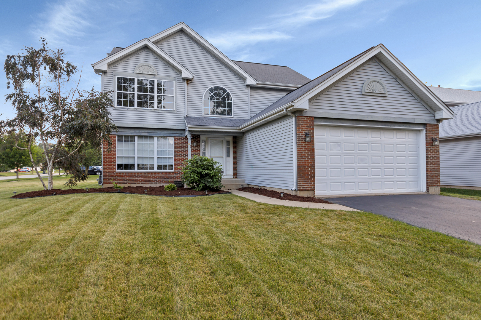 85 Old Post Road Oswego, IL 60543 - Photo 2 of 38 a front view of a house with a yard and garage