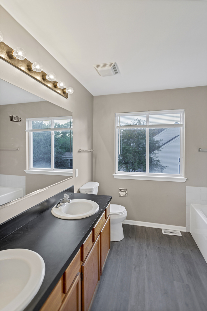 85 Old Post Road Oswego, IL 60543 - Photo 22 of 38 a bathroom with a granite countertop sink and a large mirror