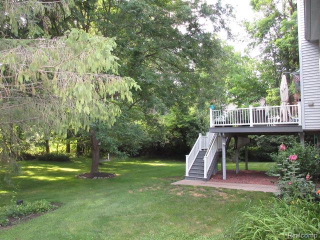 11356 Tall Shadows Court Pinckney, MI 48169 - Photo 7 of 29 Elevated deck with white railings and stairs, leading to a paver patio
