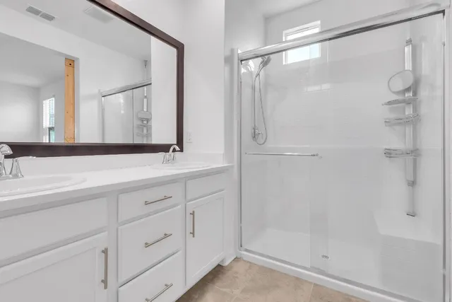 a bathroom with a shower sink and mirror