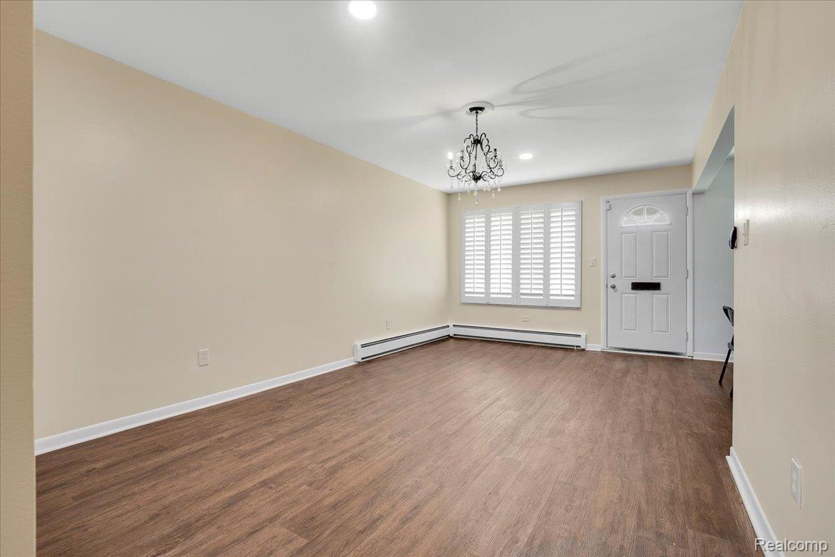 22444 Kelly Road, Unit 11 Eastpointe, MI 48021 - Photo 4 of 13 Empty room with dark wood-type flooring, a chandelier, and recessed lighting