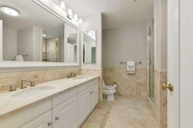 a bathroom with a granite countertop sink mirror and toilet