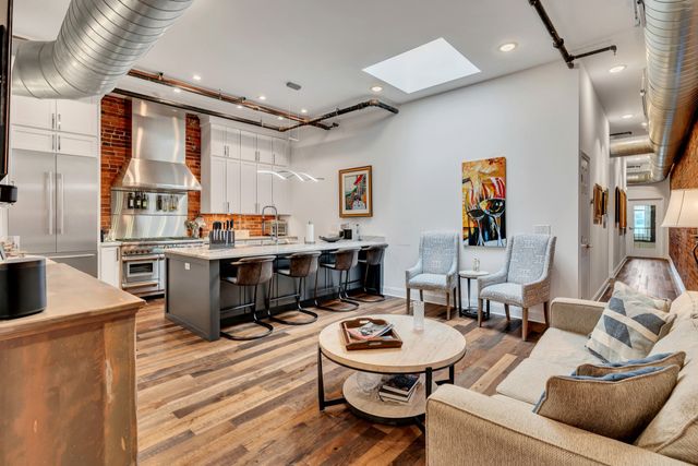 a living room with stainless steel appliances kitchen island granite countertop furniture and a kitchen view