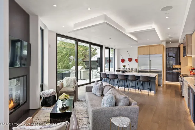 a room with stainless steel appliances kitchen island granite countertop a dining table and chairs