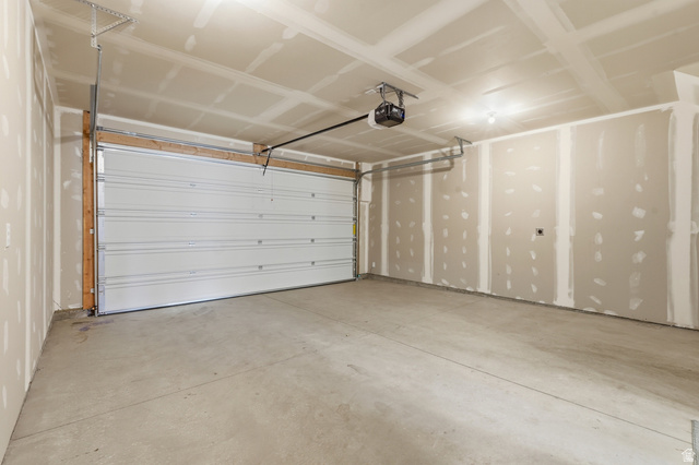 1173 West 1870 South Logan, UT 84321 - Photo 21 of 33 Spacious two-car garage featuring a sectional overhead door, automatic opener, concrete flooring, and unfinished drywall walls and ceiling