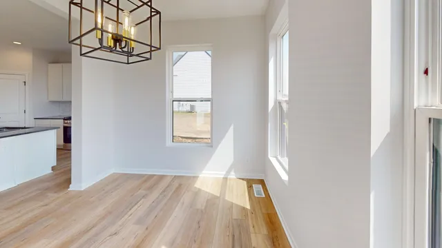 a view of empty room with wooden floor and windows