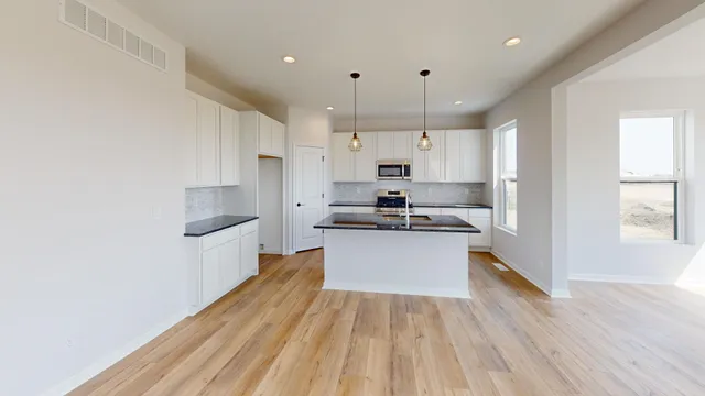 a kitchen with kitchen island a white counter top space a sink and cabinets