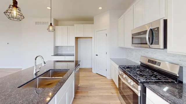 a kitchen that has a sink wooden cabinets and stainless steel appliances
