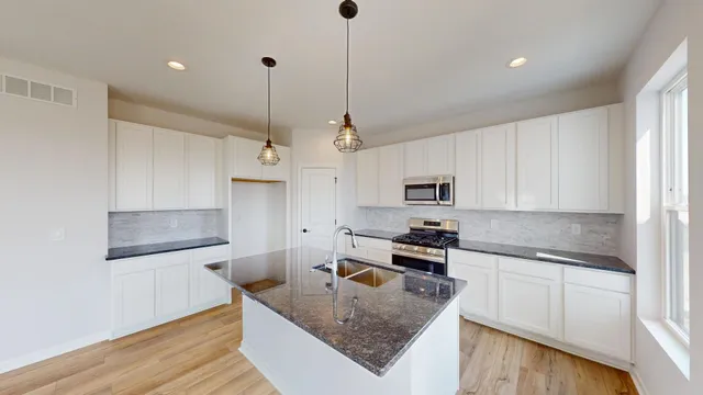 a kitchen with stainless steel appliances granite countertop a sink stove and refrigerator