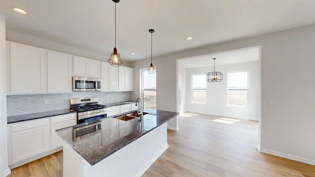 a kitchen with stainless steel appliances granite countertop a sink a stove and a refrigerator