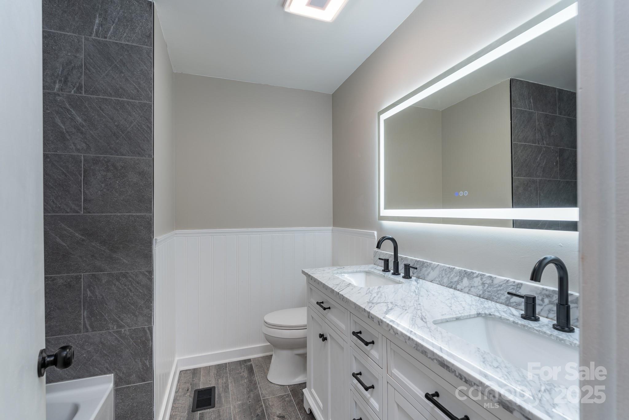 3105 West Zion Church Road Shelby, NC 28150 - Photo 16 of 44 a bathroom with a granite countertop sink a toilet and a mirror