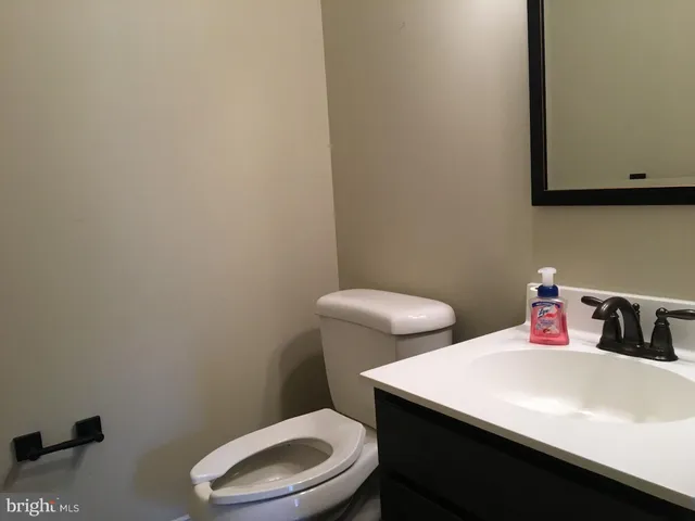 a bathroom with a toilet a sink and a mirror