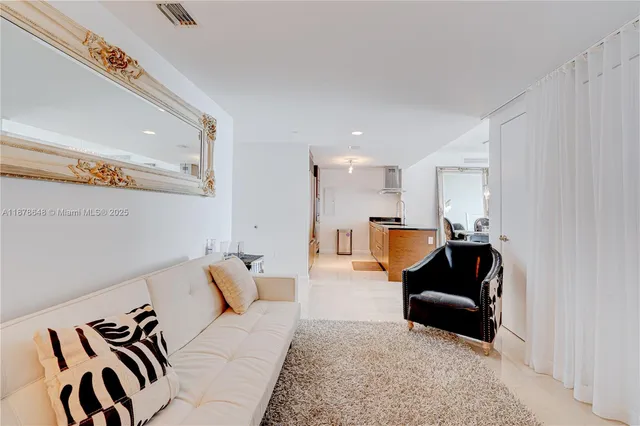 a living room with furniture and kitchen view