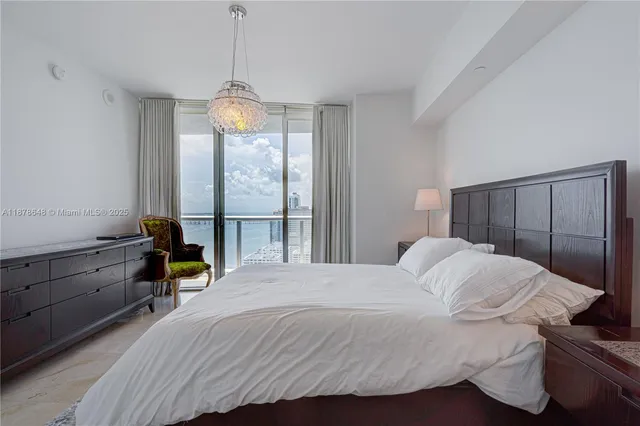 a bedroom with a bed and a chandelier