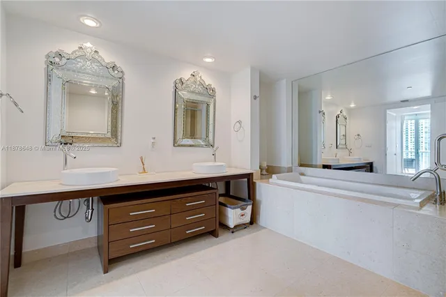 a spacious bathroom with a tub double sink and mirror