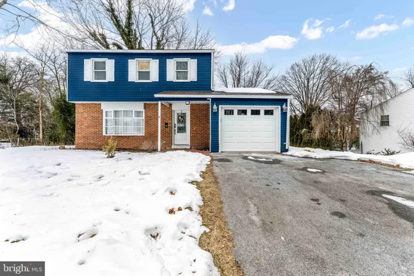 a front view of a house with a yard covered in snow