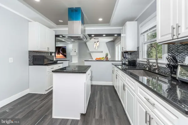 a kitchen with stainless steel appliances a sink a stove top oven a counter space and cabinets