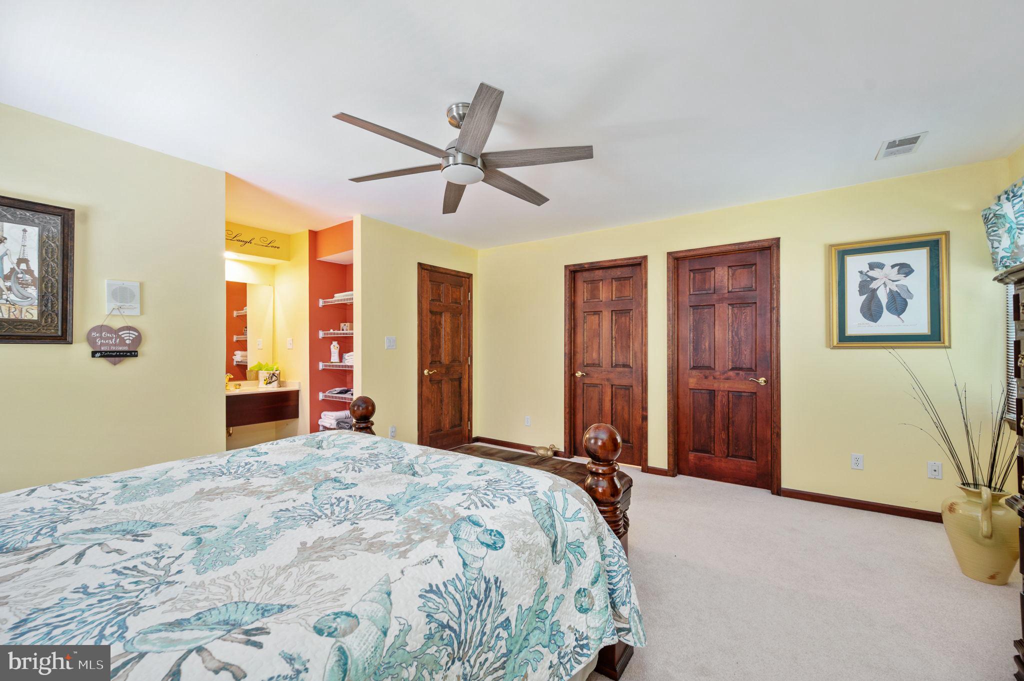 11105 Waddell Road Bumpass, VA 23024 - Photo 44 of 76 a bedroom with a large bed and a chandelier