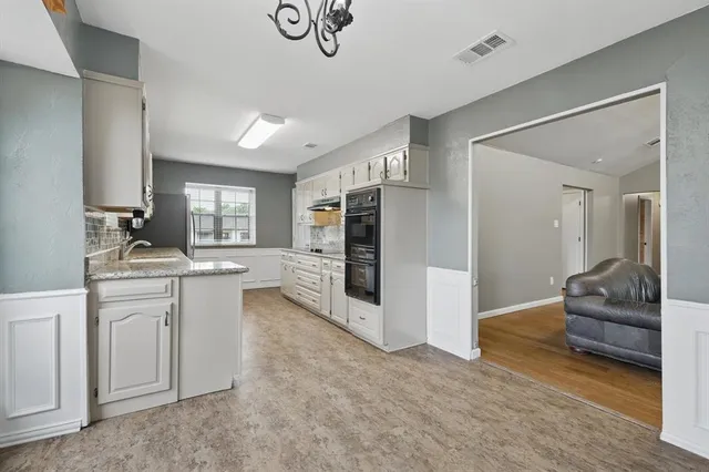 a large en suite bathroom with a granite countertop sink and mirror
