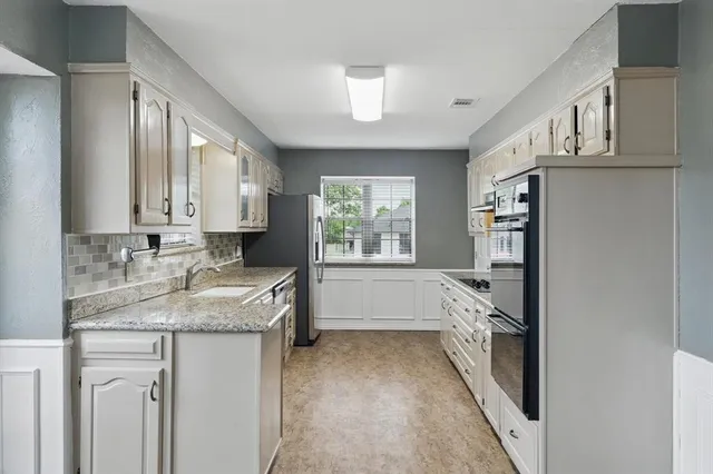 a bathroom with a granite countertop sink a vanity and a large mirror